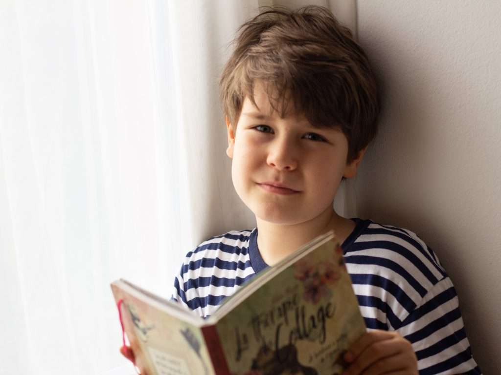 Boy looking happy while reading a book