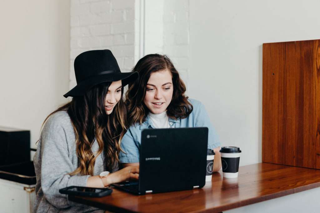 Two teen girls looking at a computer.