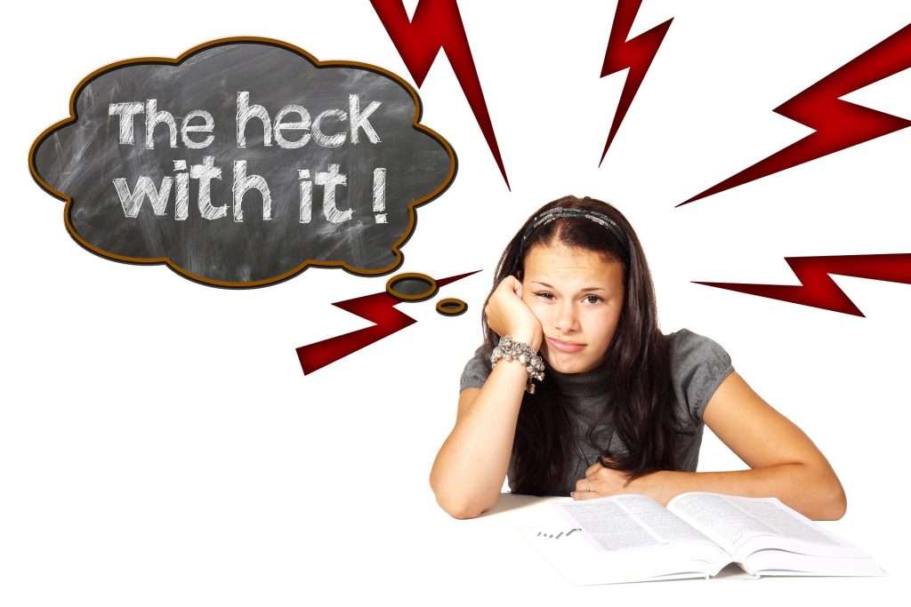 Frustrated student saying "to heck with it" in front of a book