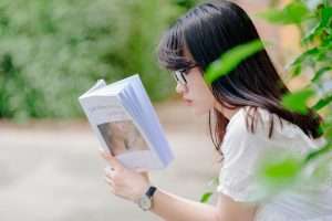Girl reading a book to get better comprehension with self-questioning.